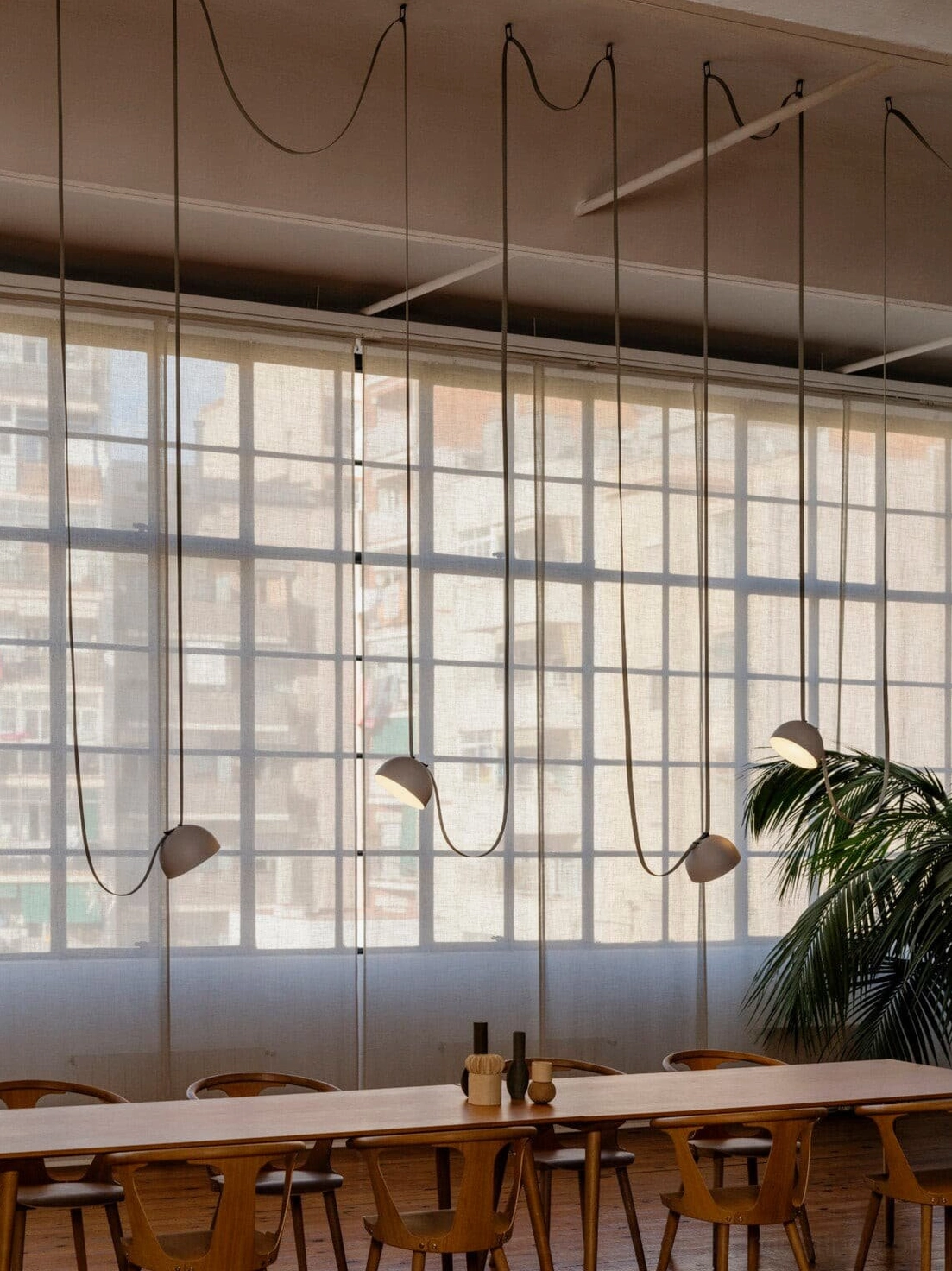 Leather sling pendant lamp fixture mounted at varying heights showing modular design flexibility