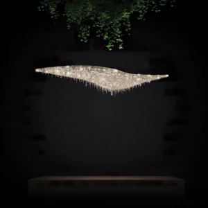 Modern leaves crystal chandelier installed over long console table in contemporary interior with hanging greenery