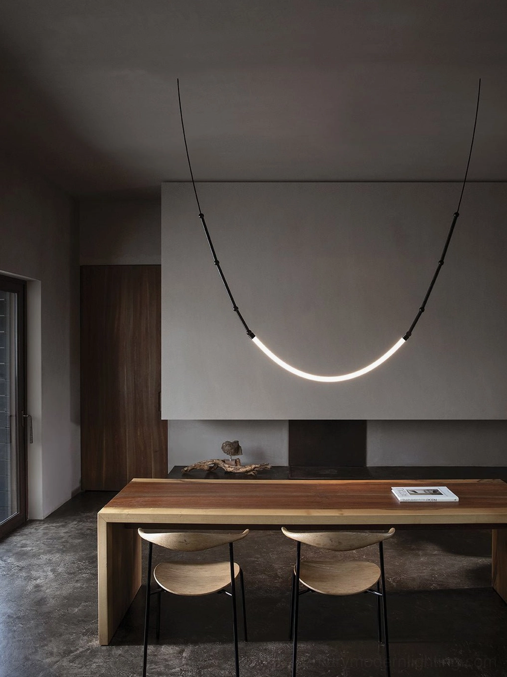 Curved linear Leda LED pendant light in monochrome industrial finish, modern minimalist dining room view