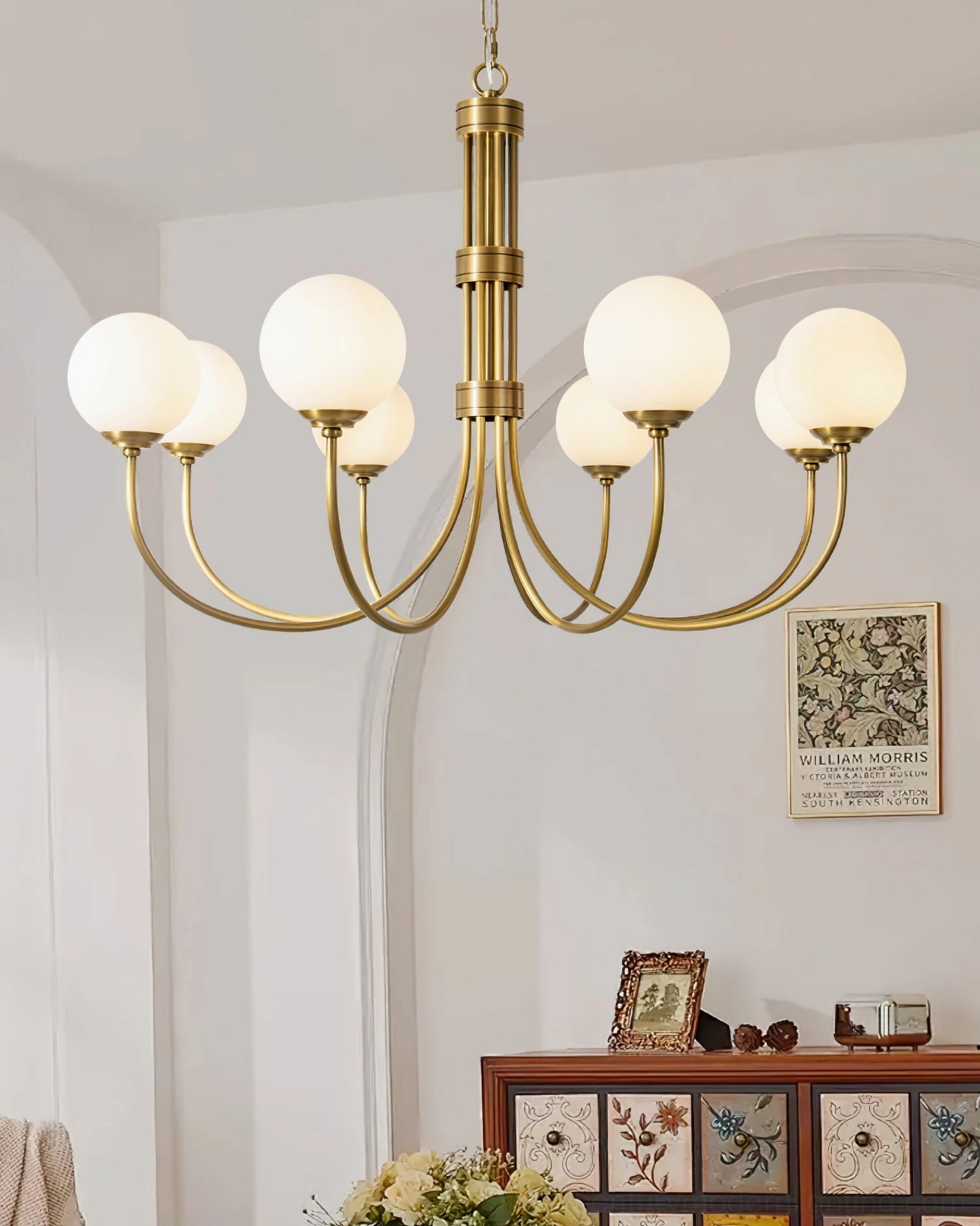 Lenore brass chandelier in vintage dining room setting with wood sideboard, retro American home decor style, warm ambient lighting