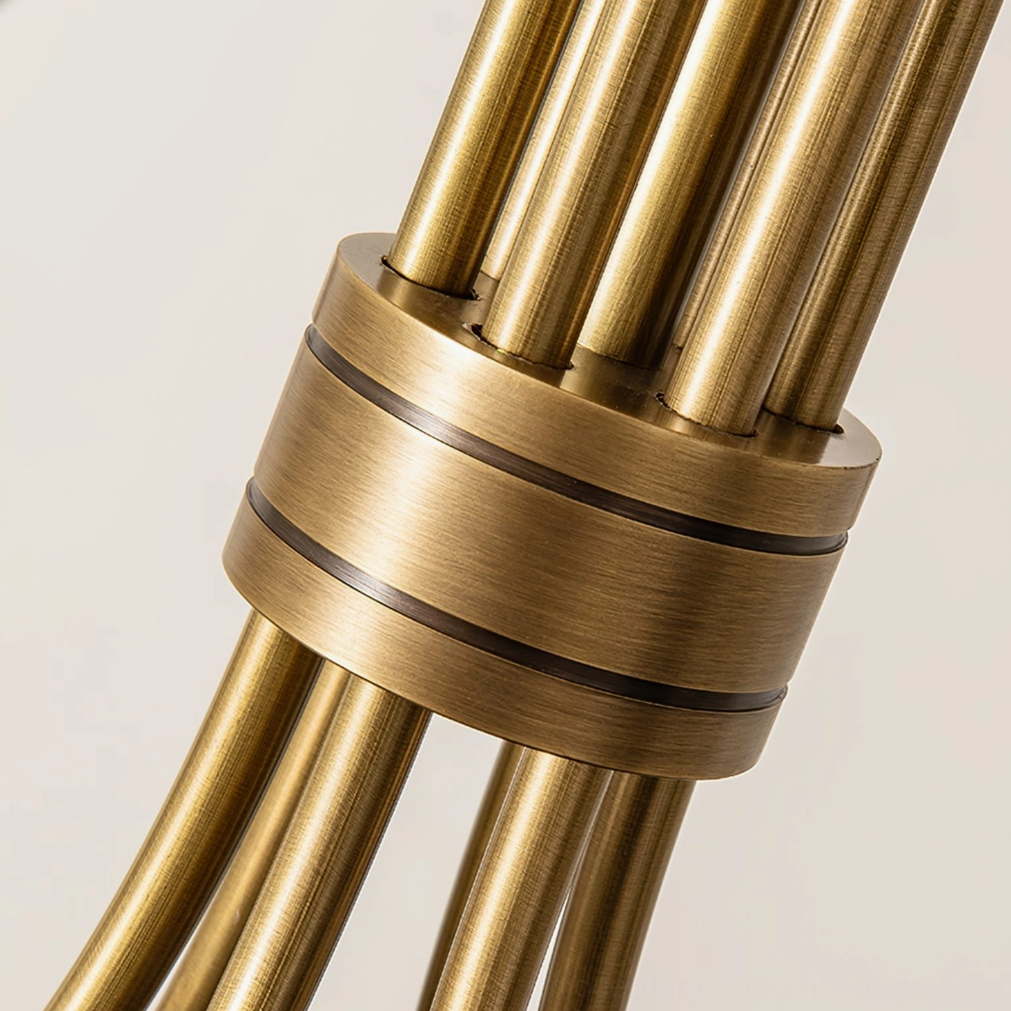 Detailed close-up of brushed antique brass chandelier arm joint and curved metal connection, macro product shot