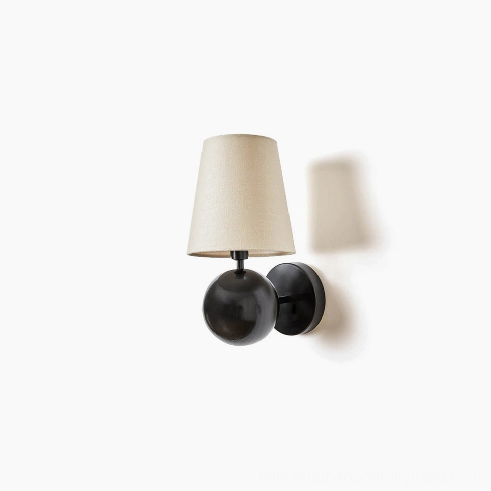Leoda modern wall sconce with black spherical brass mount and beige linen shade, front view on white background, minimalist design