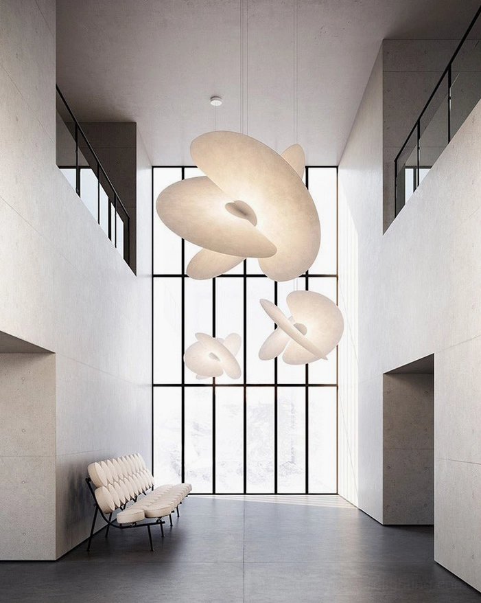 Multiple matching Levante pendant lights in double-height modern lobby, brutalist minimalist suspended disc lamps