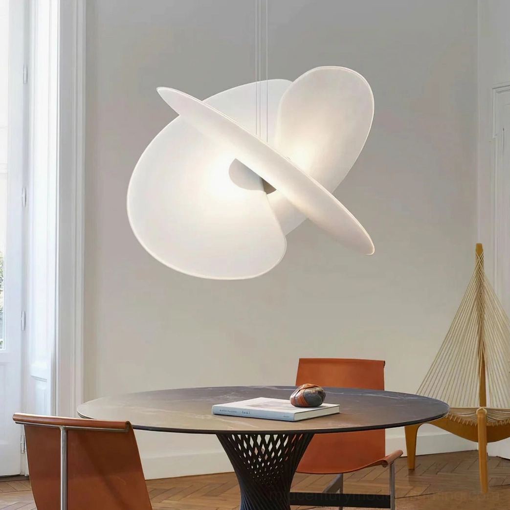 Levante organic pendant lamp in minimalist dining space, warm glowing matte finish with swirling disc design