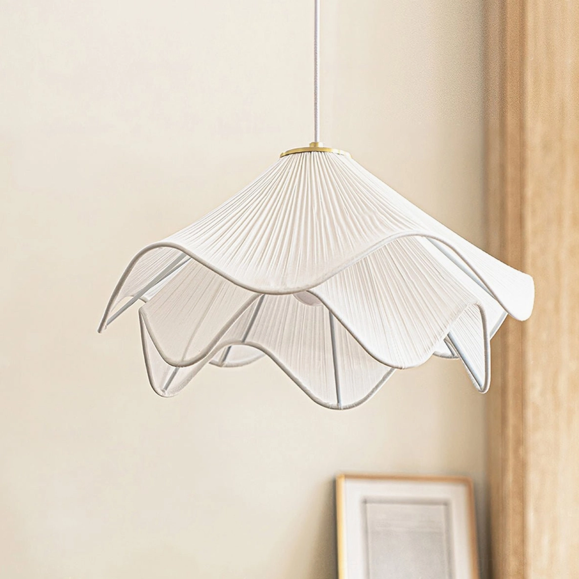 Modern Lia fabric pendant light with brass gold hardware, close-up hanging view in contemporary home interior with wall art and wooden furnishings