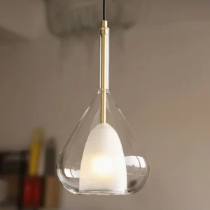 Close-up overhead view of Lila pendant showing dual-glass teardrop design and brass stem detail