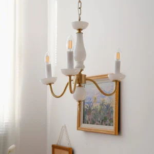 6-arm brass and white ceramic candle chandelier displayed in elegant retro interior setting with framed artwork