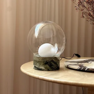 Lilly marble table lamp styled on round side table in luxury living room with beige curtains
