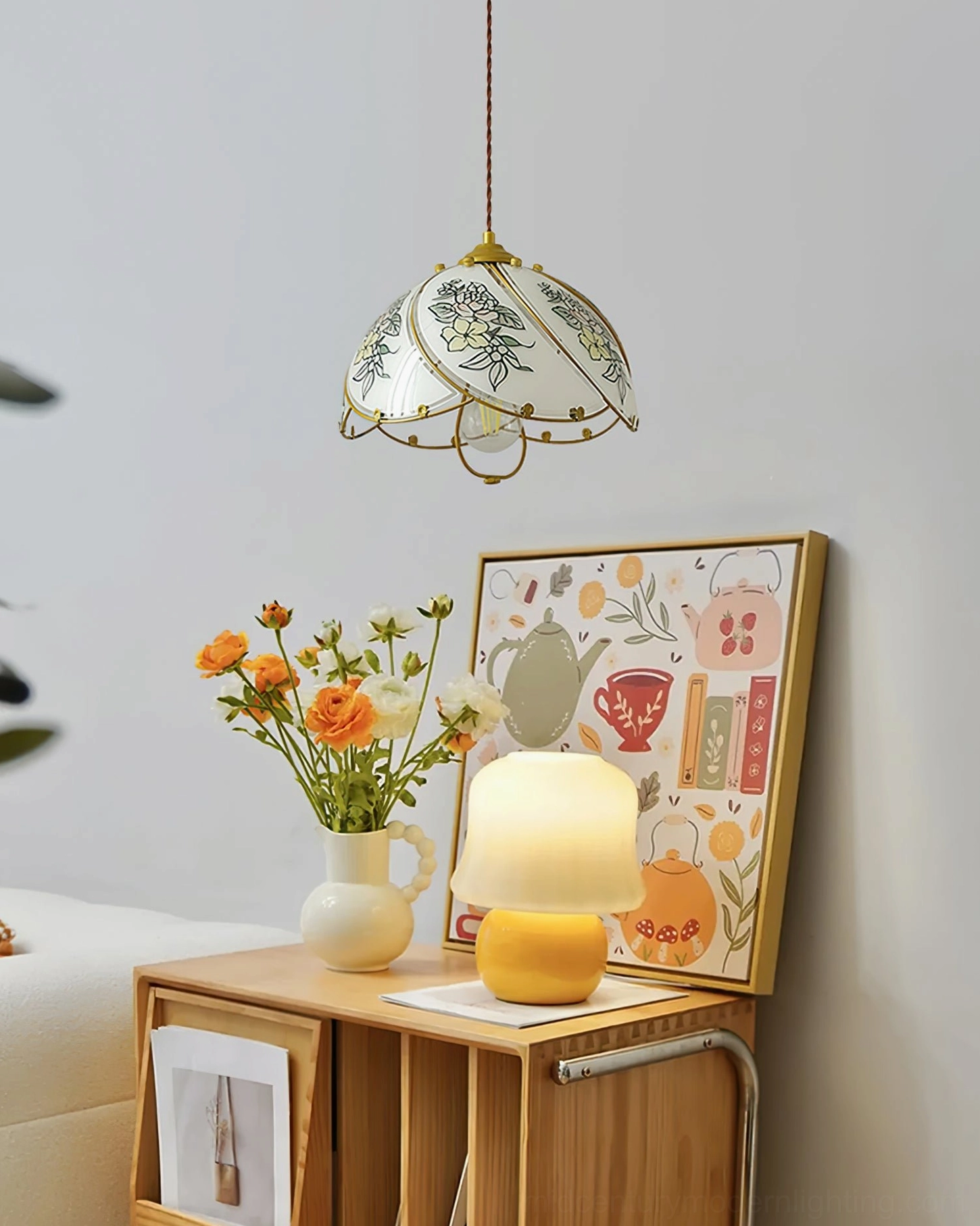Botanical pendant lamp hanging in cozy bedroom corner with rustic wooden nightstand, table lamp, and botanical wall art decor