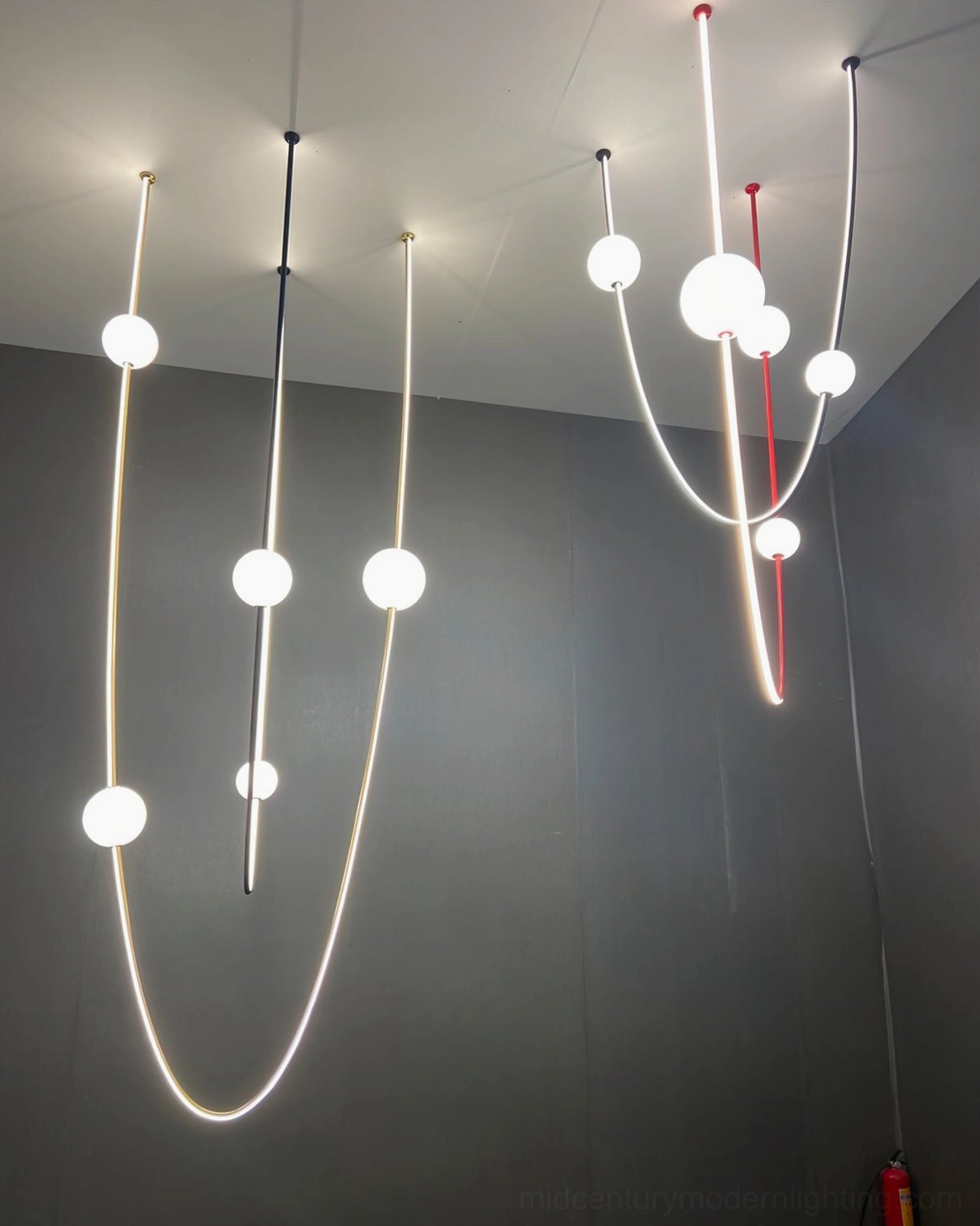 Linea Curva curved pendant chandelier in gold finish with frosted glass balls modern mid-century lighting