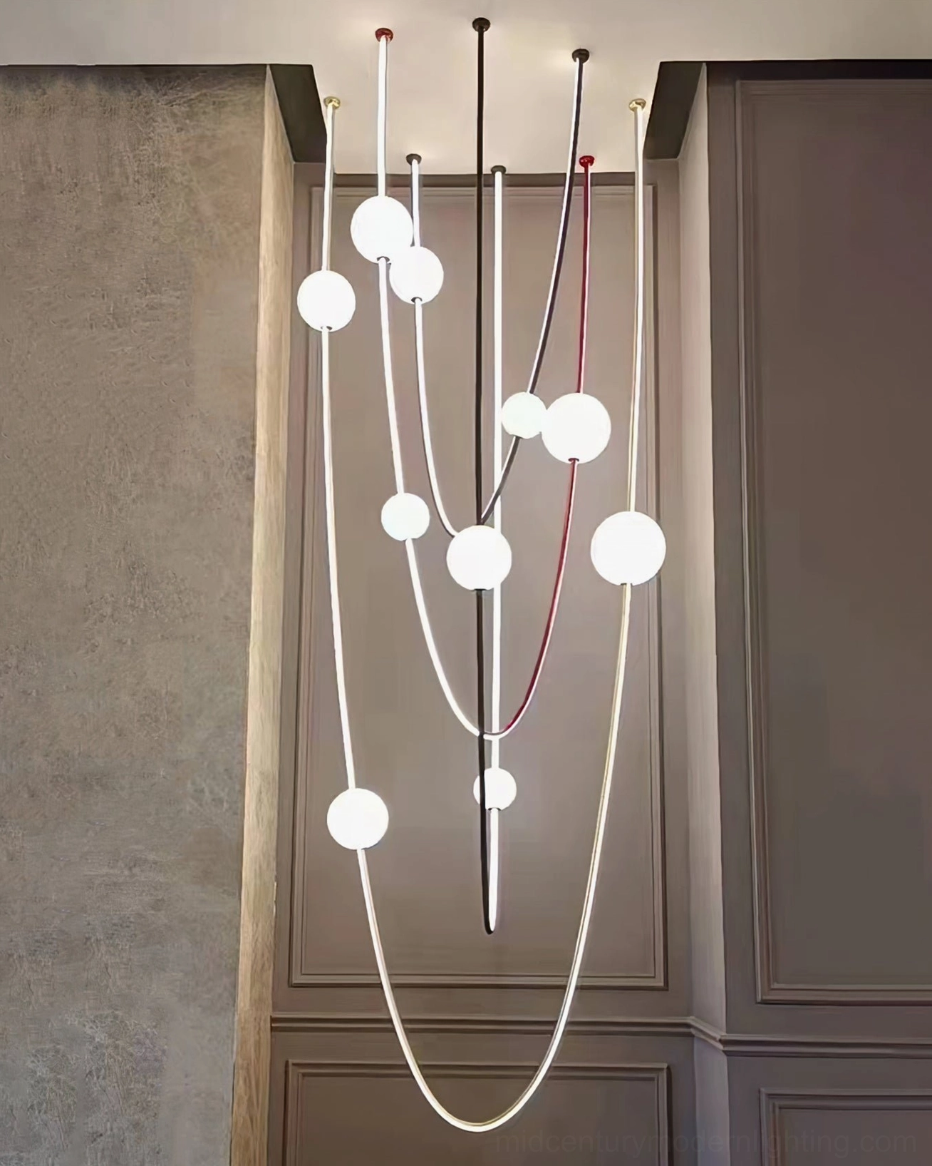 Large-scale Linea Curva multi-strand curved pendant in modern hallway with high ceilings contemporary design