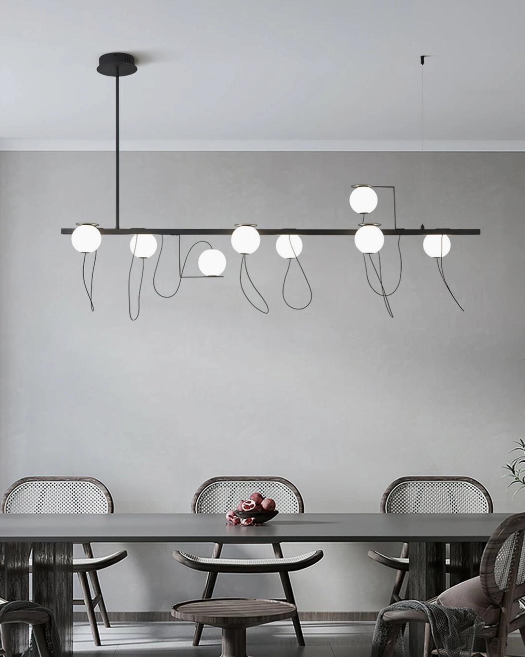 Linear square canopy magnetic bubble chandelier suspended above dining table in modern dining space