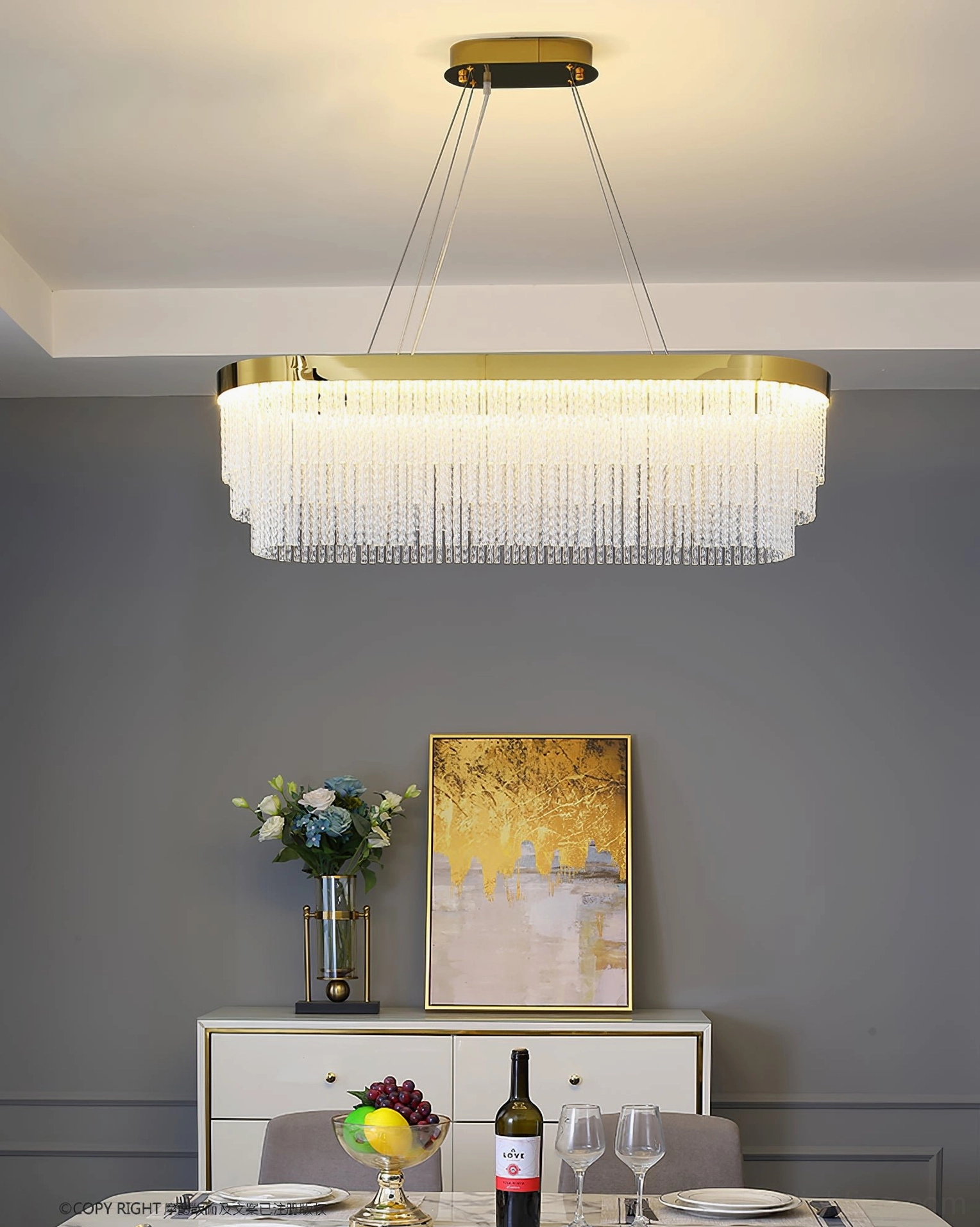 Elongated rectangular crystal pendant with warm illuminated light over formal dining table setting