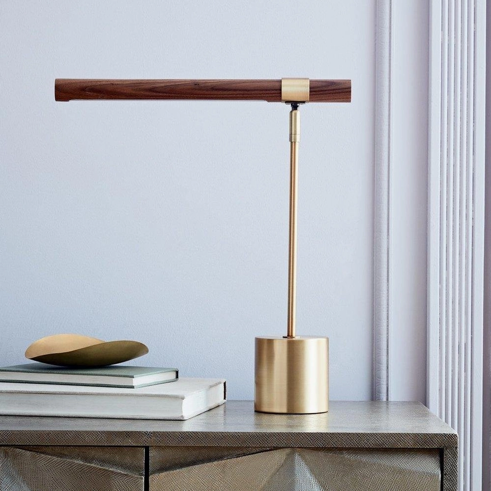 Minimalist T-shaped desk lamp on console table, modern walnut and brass styling unlit daytime view