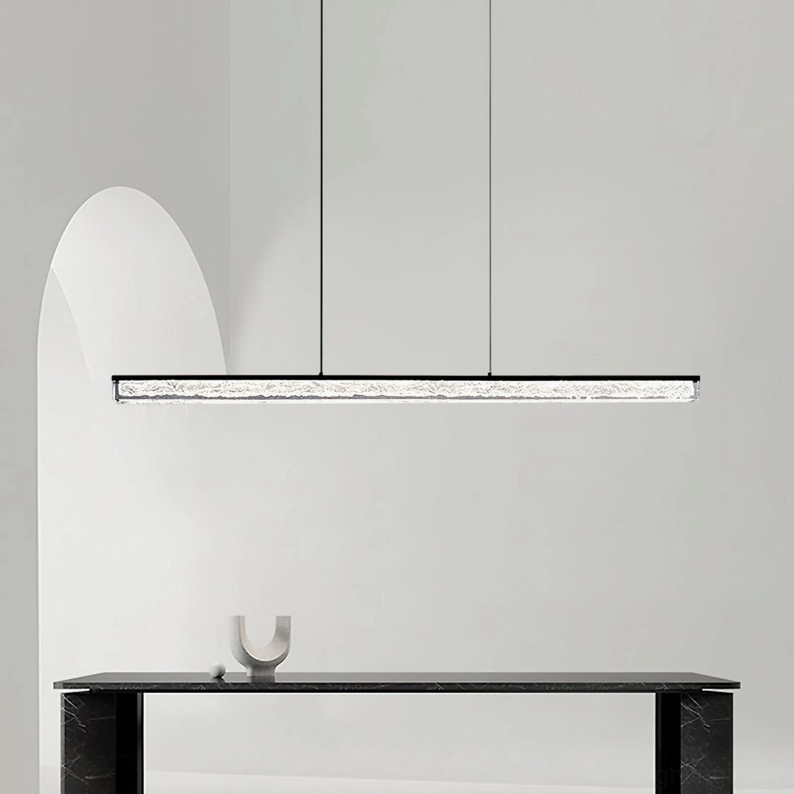 Side angle view of linear LED pendant fixture in contemporary minimalist entryway with console table