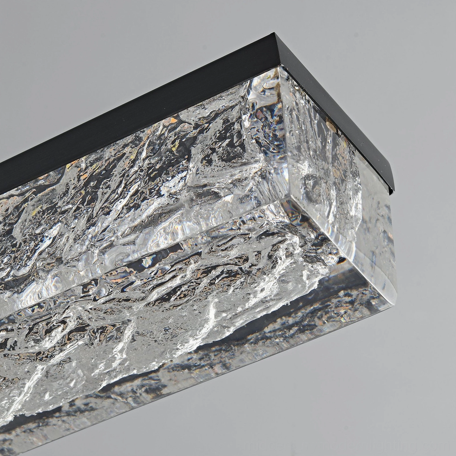 Close-up macro detail of rippled textured clear glass shade and black metal frame junction