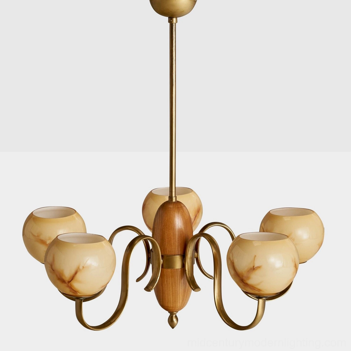 Linnea mid-century chandelier featuring matte rounded beige glass shades with curved brass arms in studio view