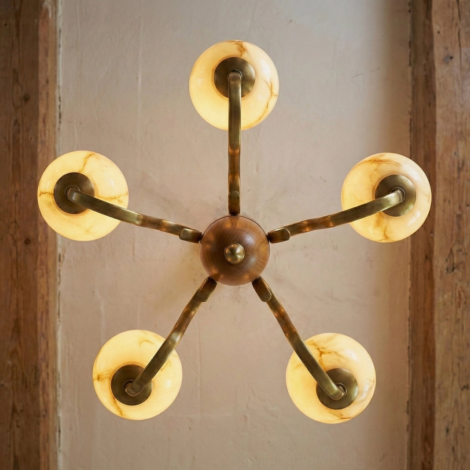 Linnea sputnik-style chandelier top-down view showing radial brass arms and wooden central hub with rounded glass shades