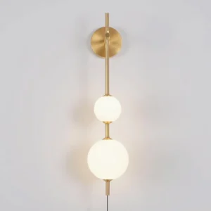 Modern brass globe wall lamp lit with warm 3000K LED light, two-tier frosted glass spheres, minimalist design