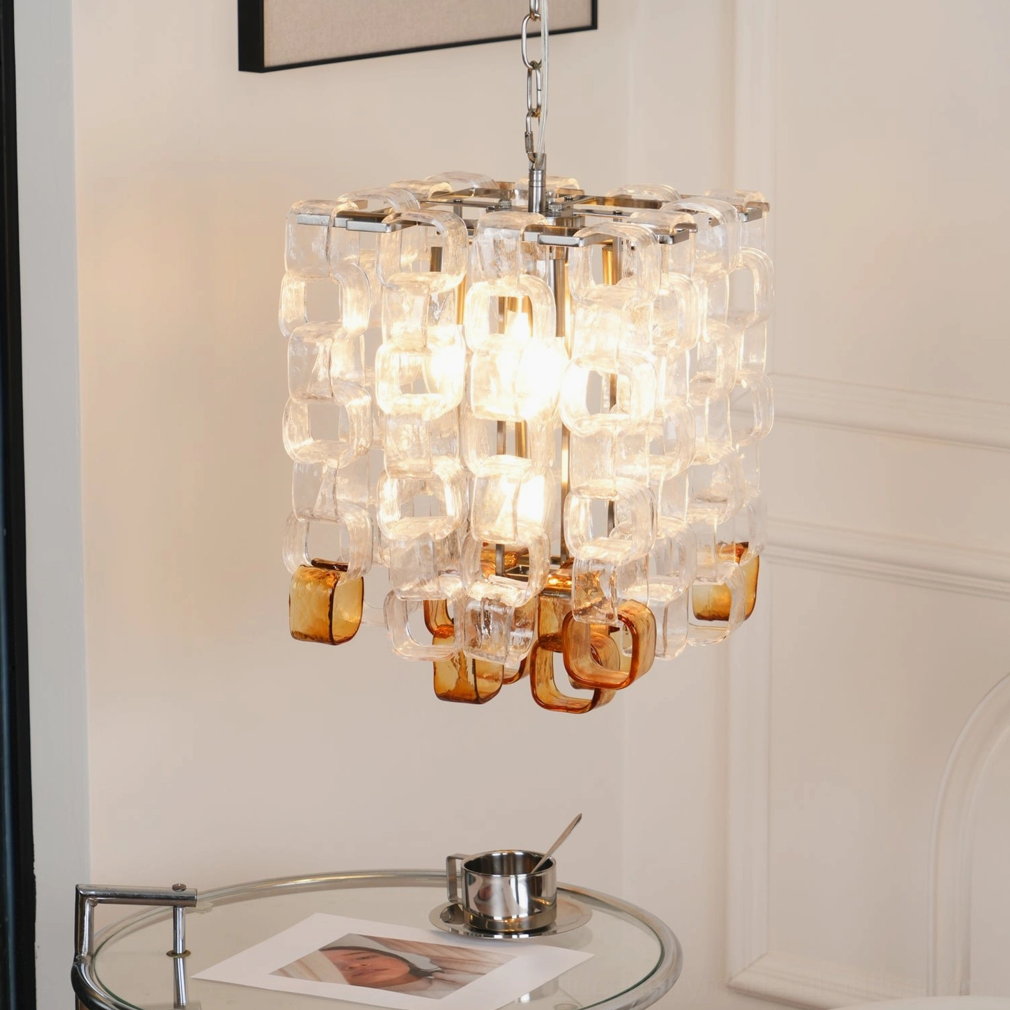 Elodie Murano chandelier illuminated with warm light glowing through glass blocks, close hanging view in minimalist interior