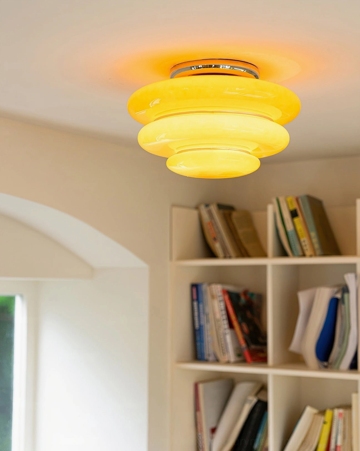 Lit orange tiered ceiling lamp close-up soft warm yellow glass illumination