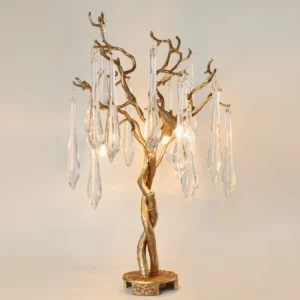 Illuminated Teardrop Branch Table Lamp displaying warm ambient light through glass teardrops and glowing gold twisted metal trunk base
