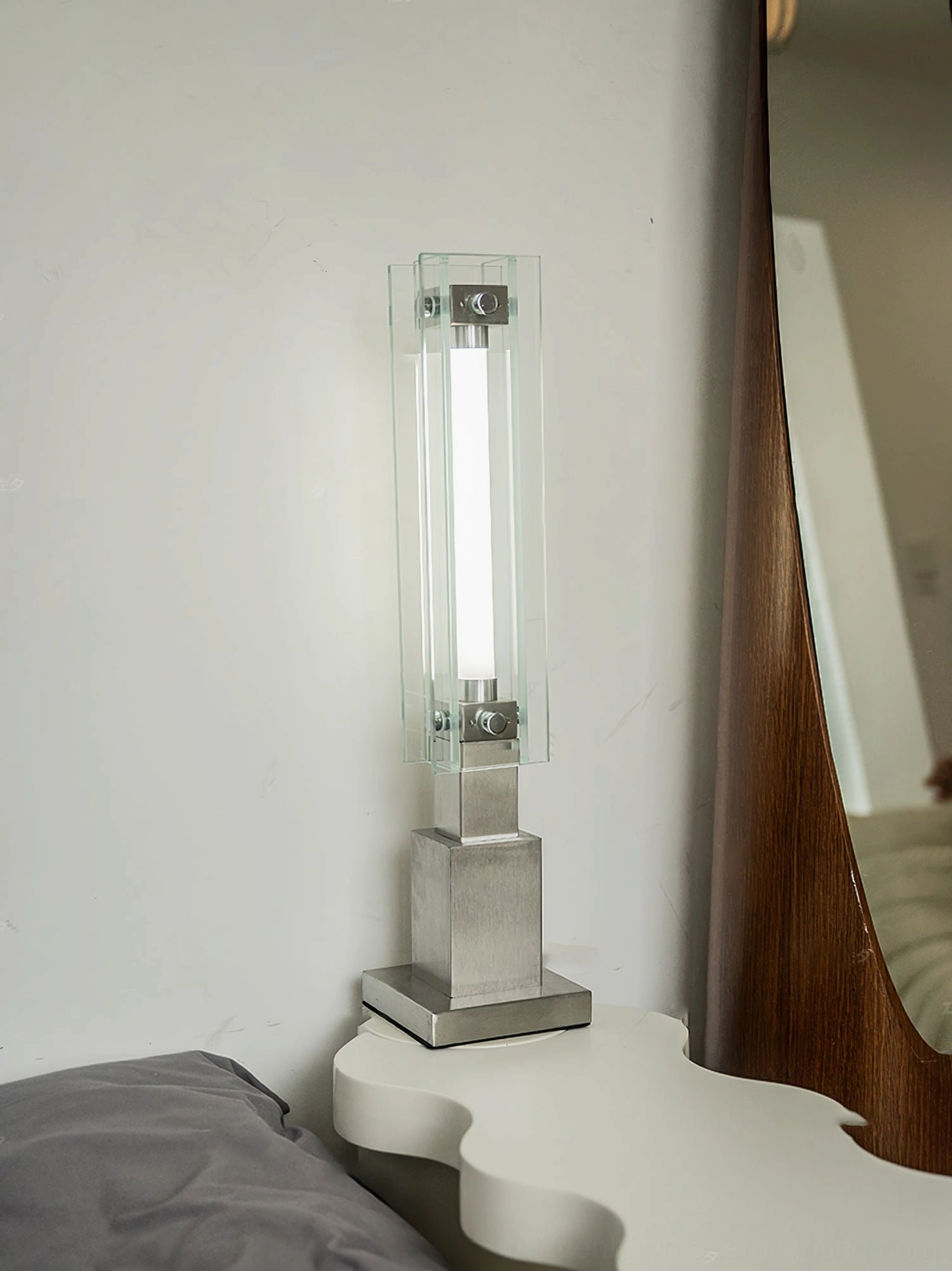 Modern minimalist table lamp positioned in living room near storage cabinet and vinyl records