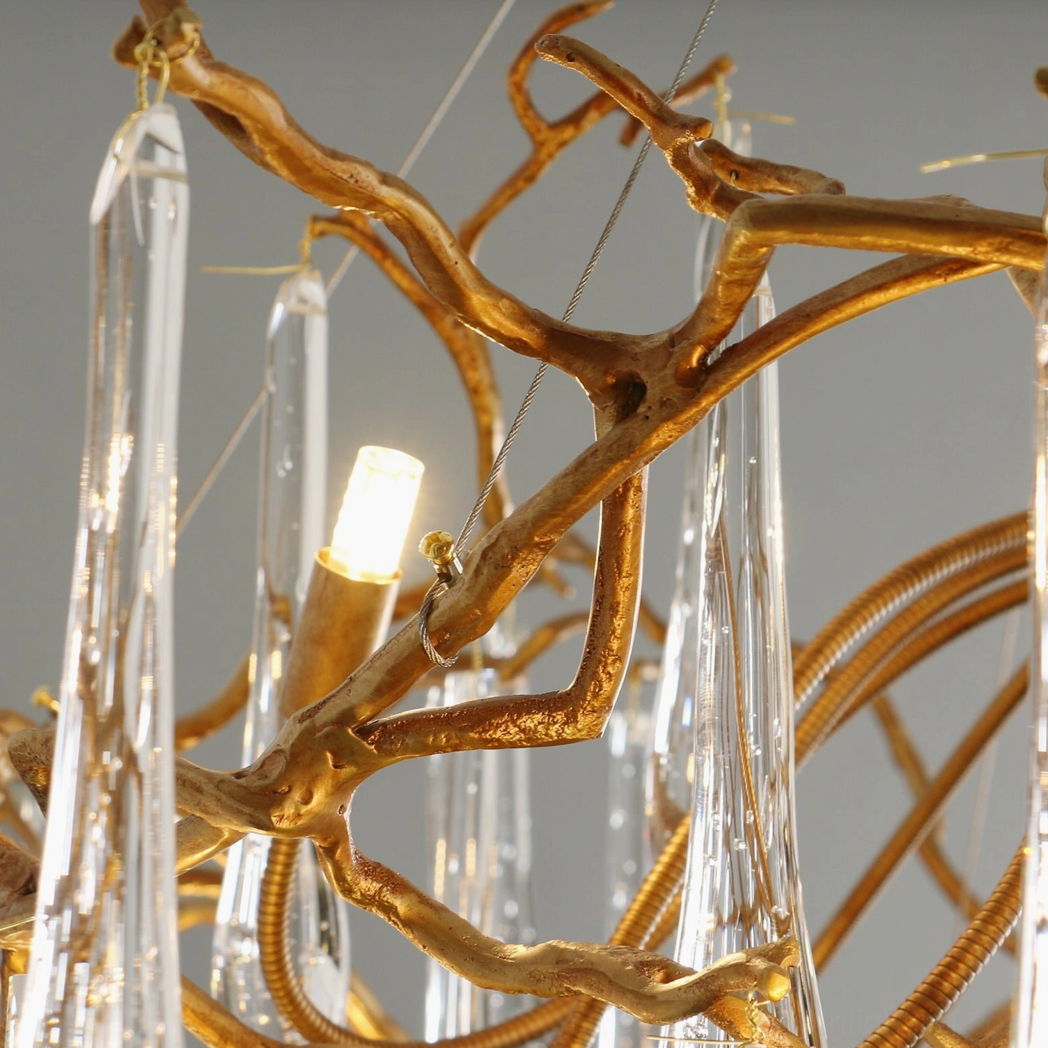Extreme close-up detail of Livio Chandelier showing delicate brass frame, crystal pendant suspension, and LED light source