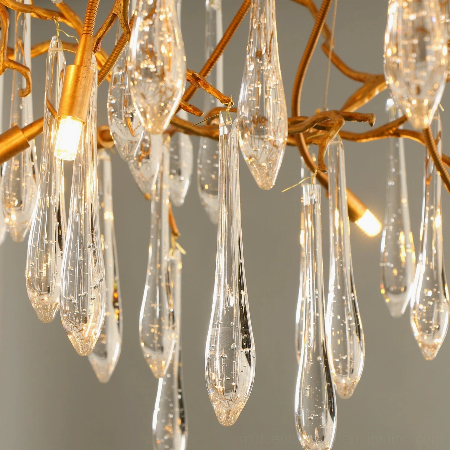 Front close-up of Livio Crystal Chandelier with warm glowing LED bulbs highlighting bubbled teardrop crystals