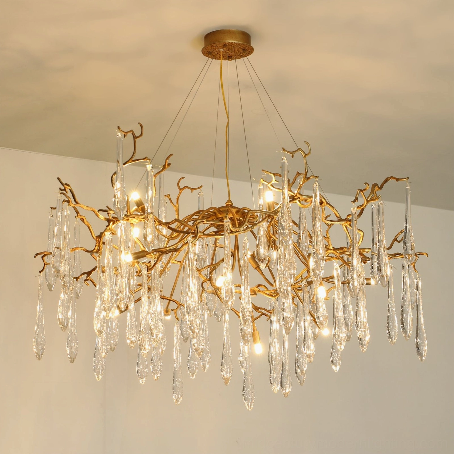 Livio Branch Chandelier low-angle front view highlighting organic brass framework and cascading crystal droplets