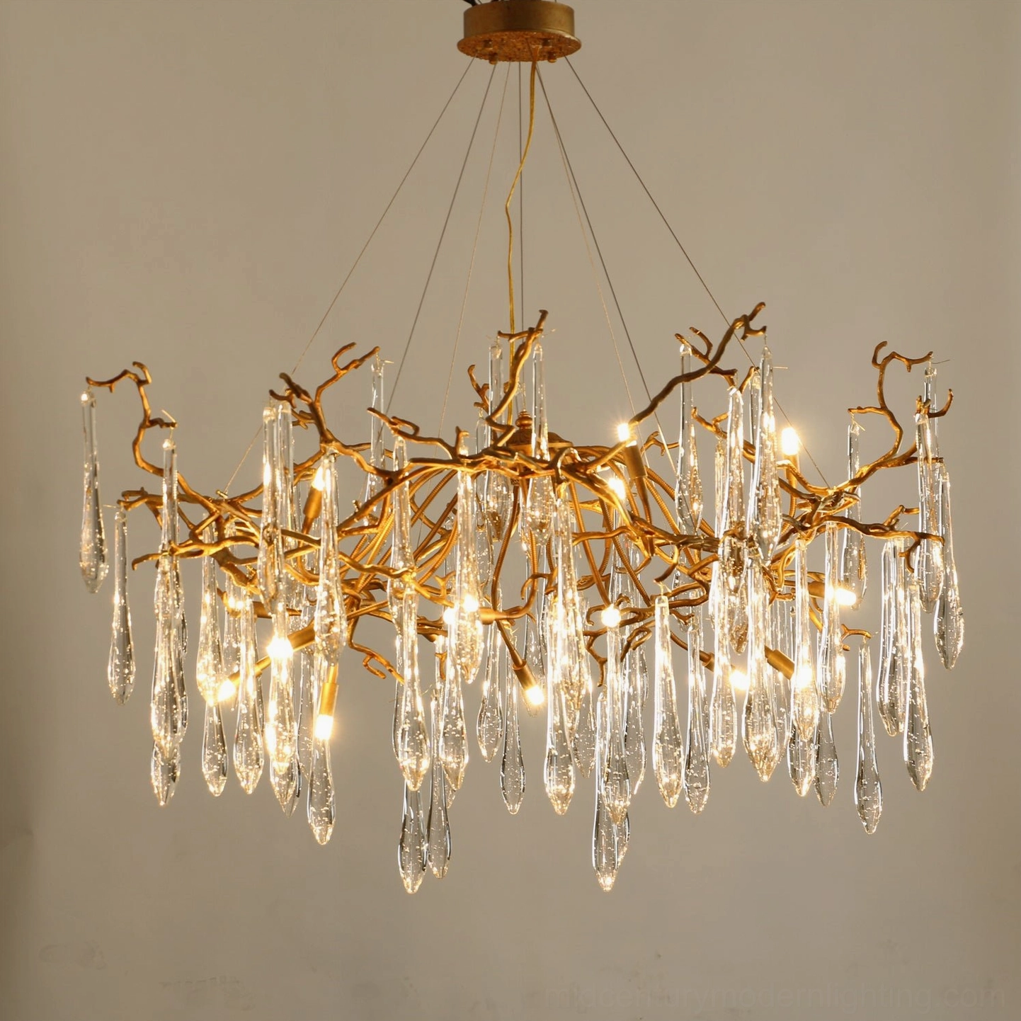 Overhead close-up of Livio Chandelier showing intricate brass branch structure and crystal pendant illumination
