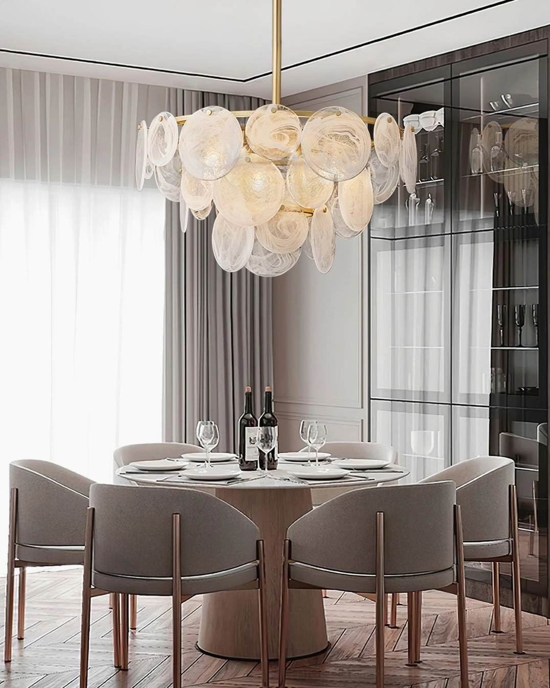 Loire Chandelier suspended above round dining table in modern dining room with glass cabinet and taupe upholstered chairs