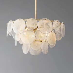 Close-up detail of Loire Chandelier illuminated frosted glass pendants with warm light glow and brushed brass framework