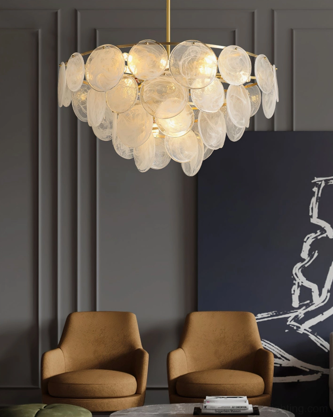 Illuminated Loire Chandelier above tan leather armchairs in modern lounge with dark gray accent walls