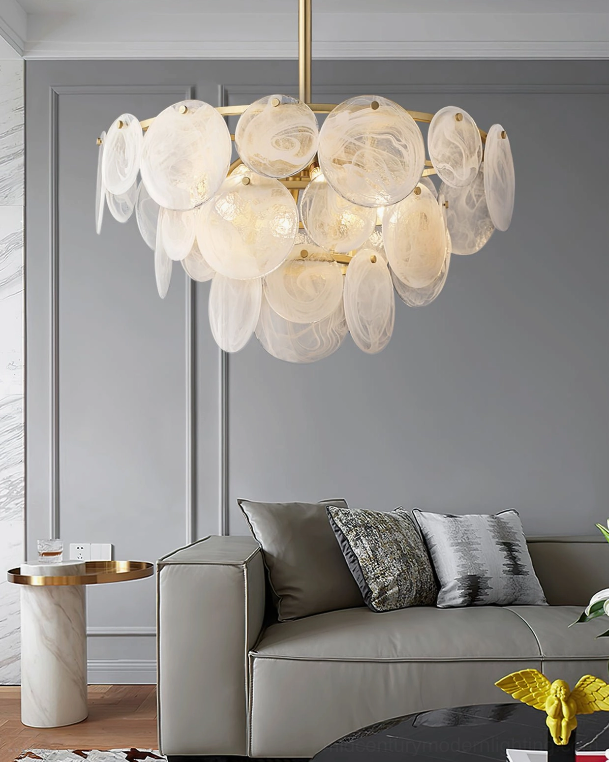 Loire Brass Chandelier hanging above gray fabric sofa in minimalist modern living room with decorative pillows
