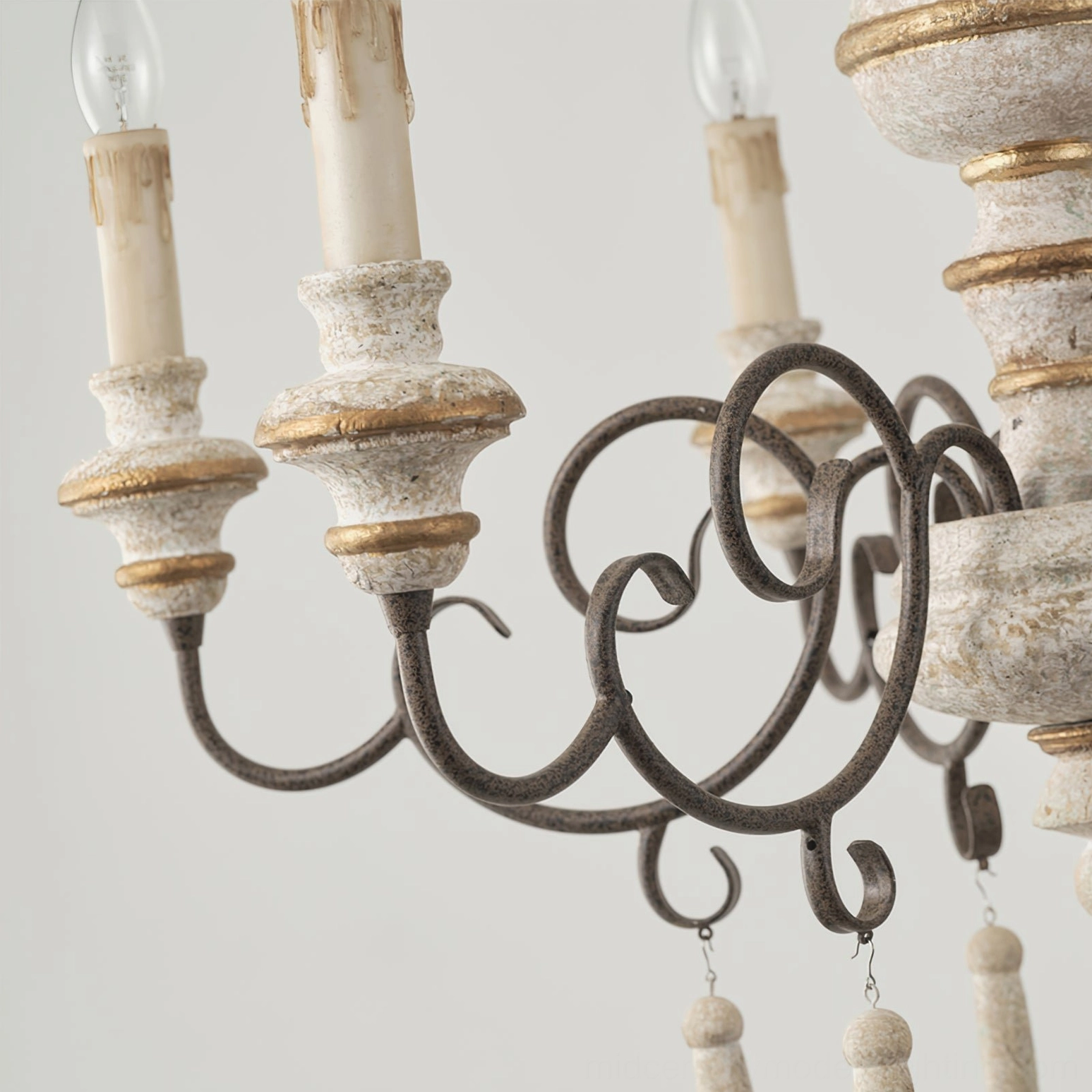 Detailed side view of Lomba chandelier arm assembly with candle-style sleeves and distressed metal pendants