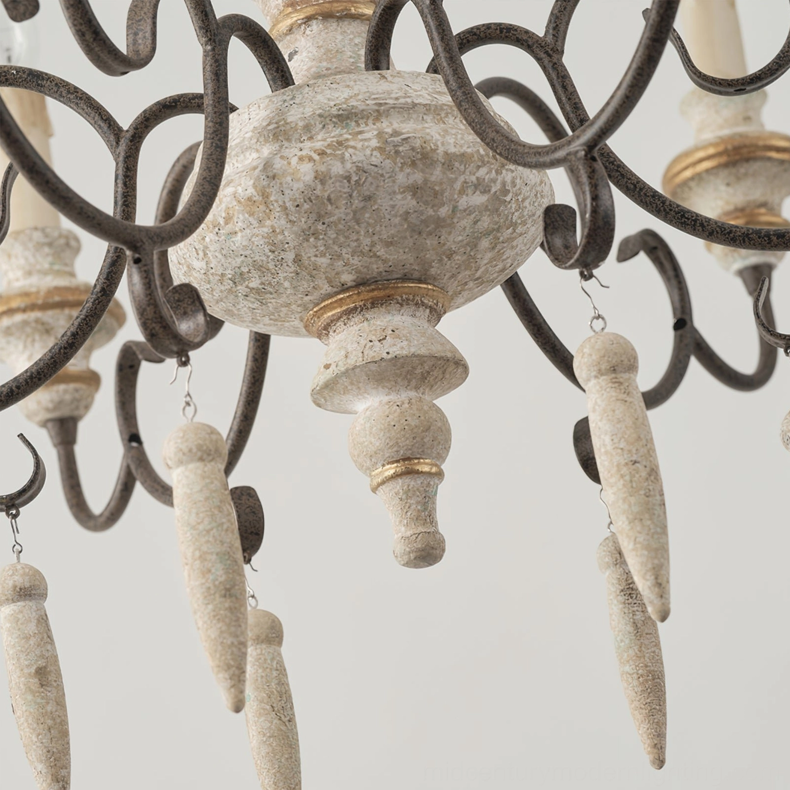 Close-up detail of Lomba chandelier showing ornate scrollwork, gold trim bands, and aged patina on iron frame