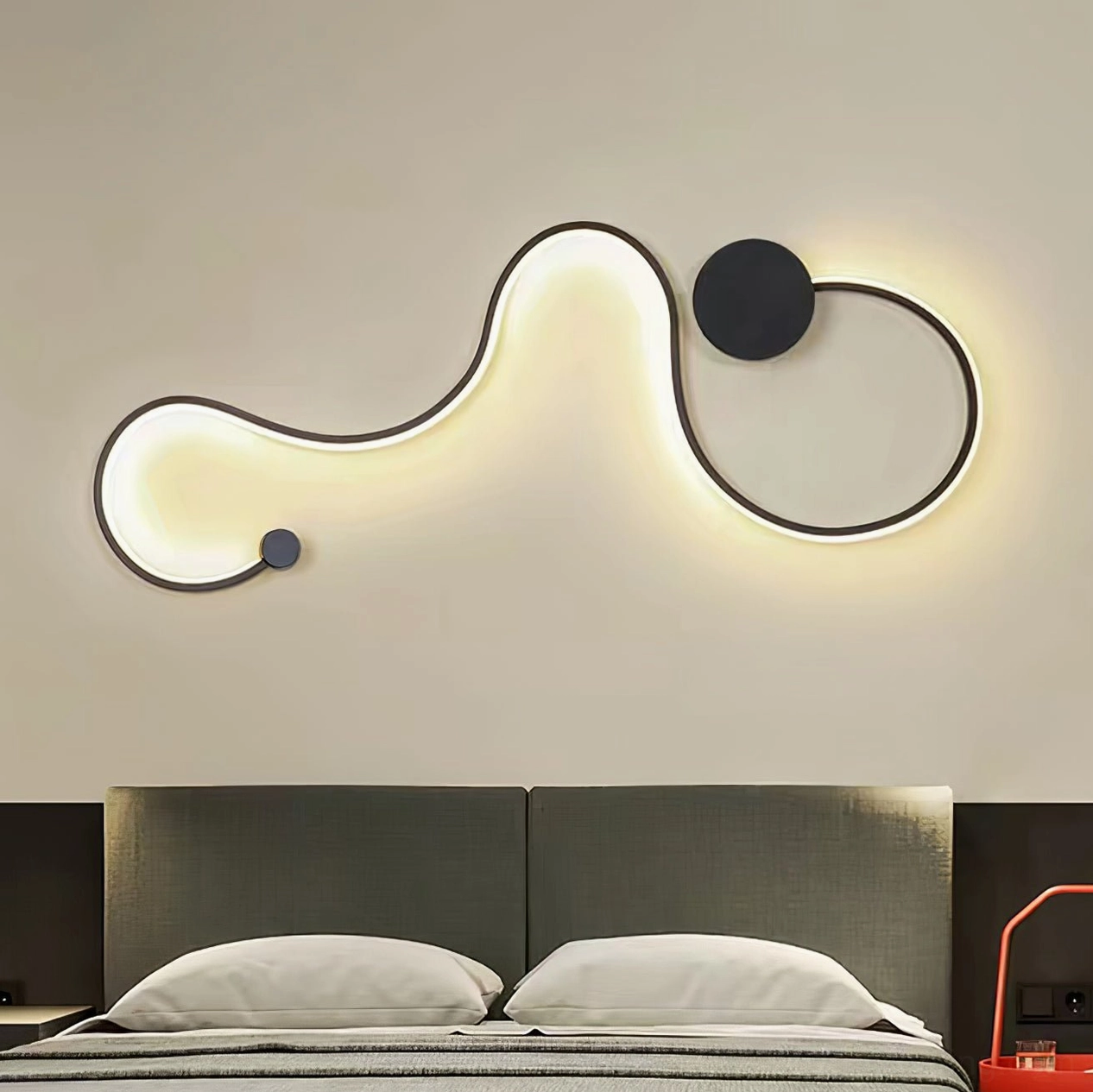Extended wavy snake wall lamp above double bed providing modern minimalist warm ambient light
