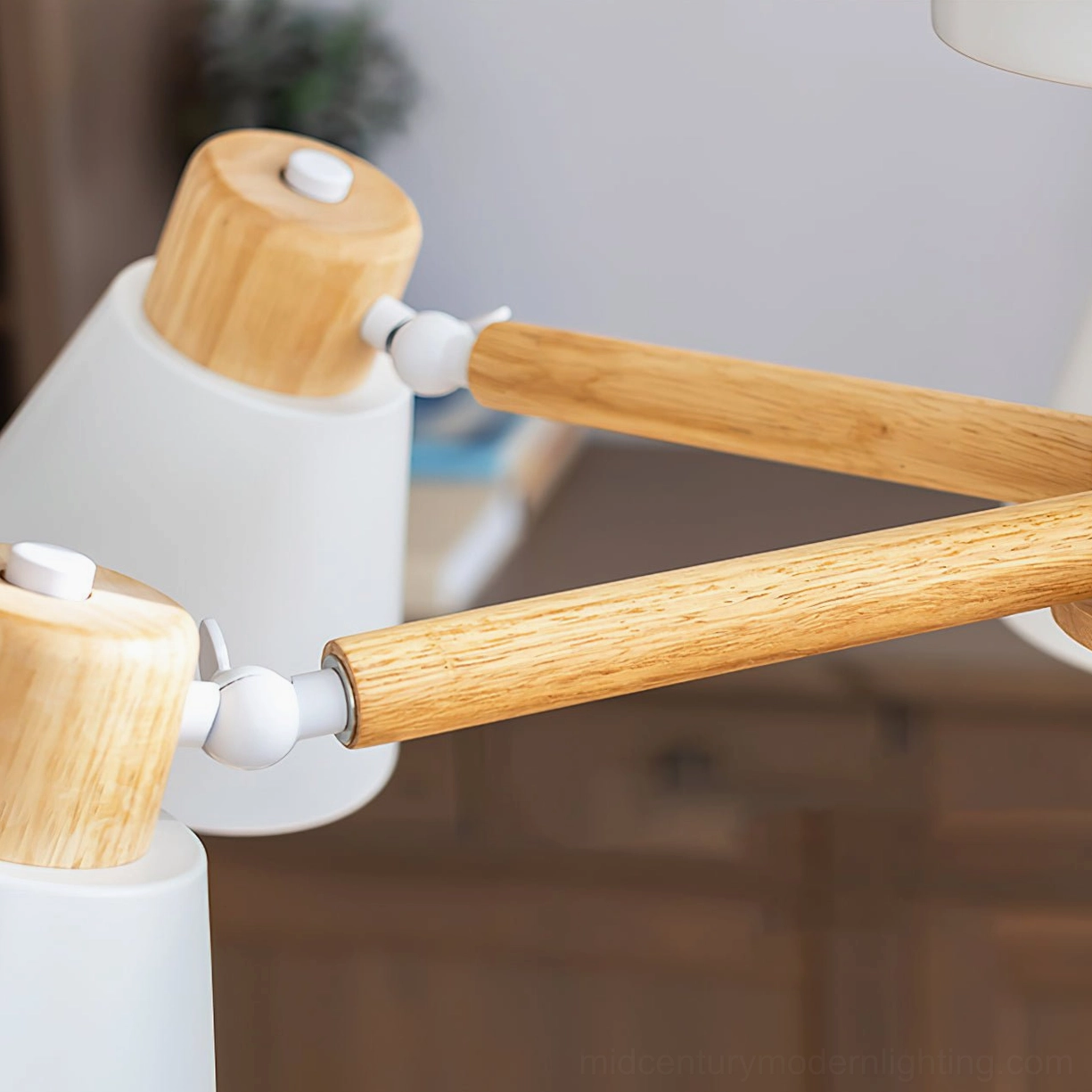 Close-up detail of Loona ceiling lamp wood arm joint with metal rotating cap and natural wood grain texture