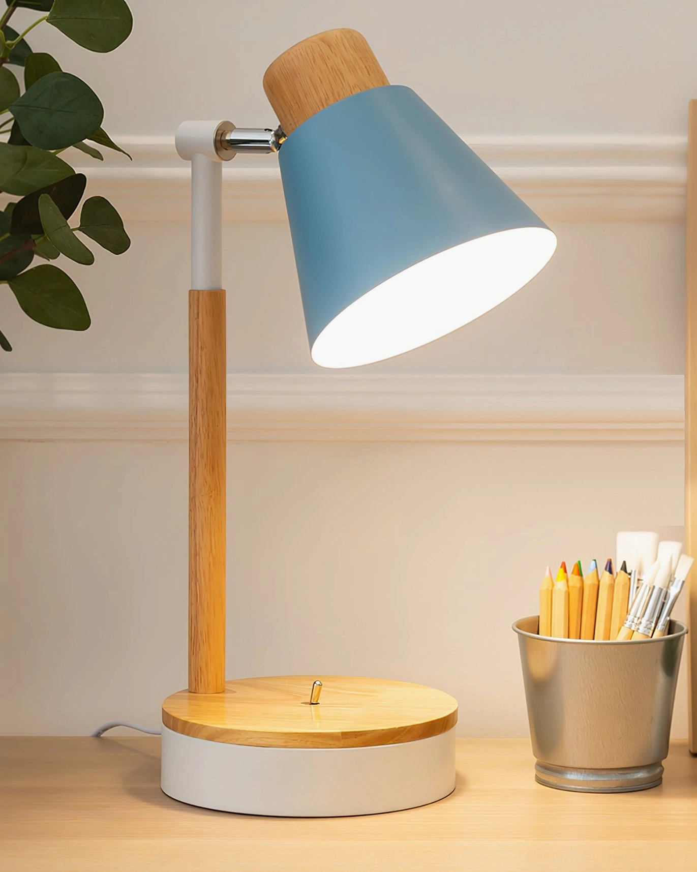 Light blue matte Loona Nordic table lamp on home office desktop with natural wood details and pen holder