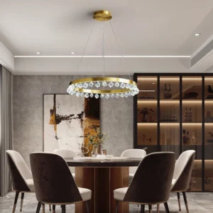 Loop Crystal Chandelier installed in modern dining room with matte gold frame and hanging crystal accents