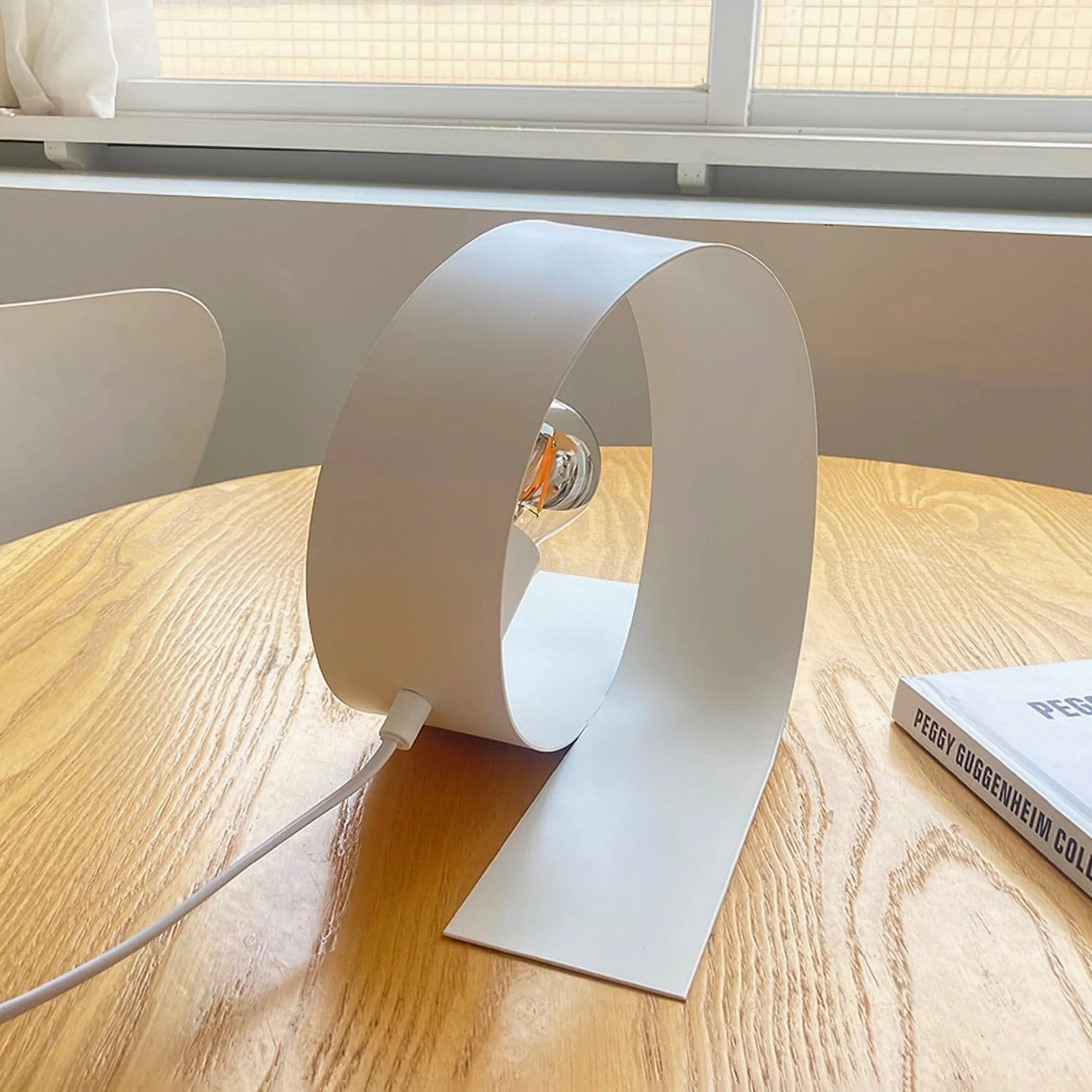 Looping modern table lamp white metal construction detail view