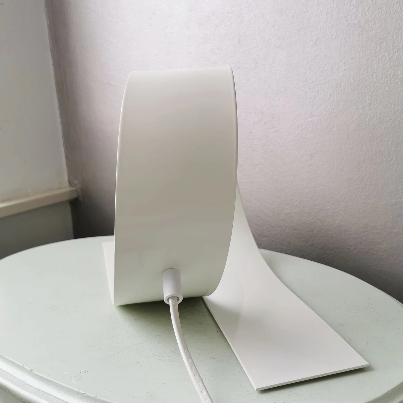 Looping white table lamp profile silhouette on neutral background