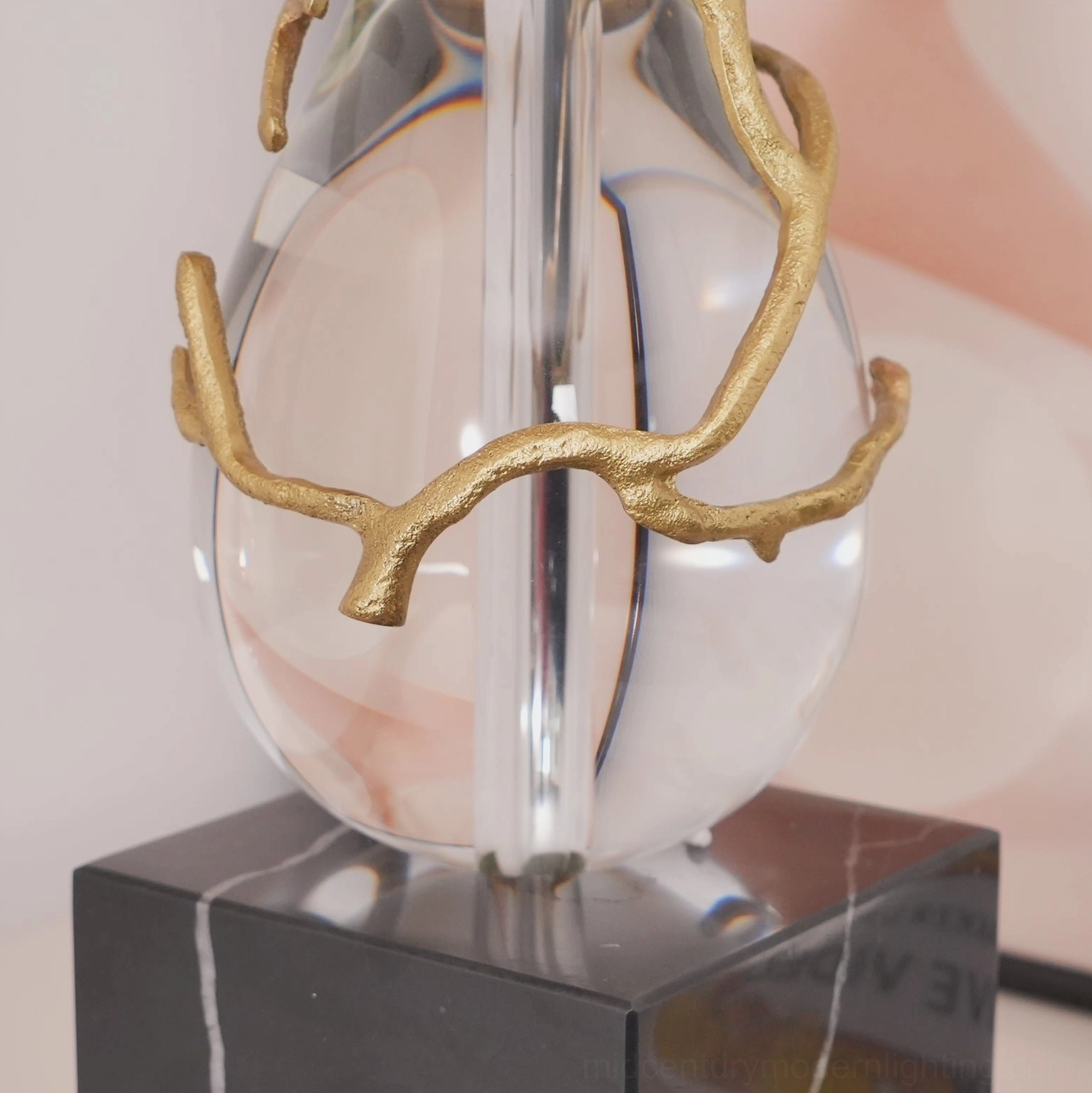 Lora table lamp base close-up detail showing black marble foundation with crystal orb wrapped in gold branches