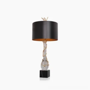 Lora table lamp front studio view with black drum shade, gold twig finial, brass accents, and black marble base on white background