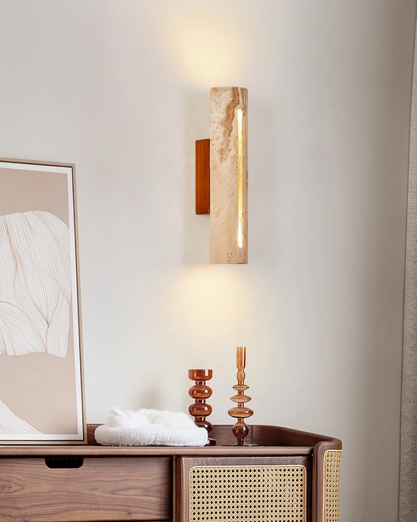 Lorelei travertine wall sconce in living room console table setting with wabi-sabi minimalist home decor and warm accent lighting