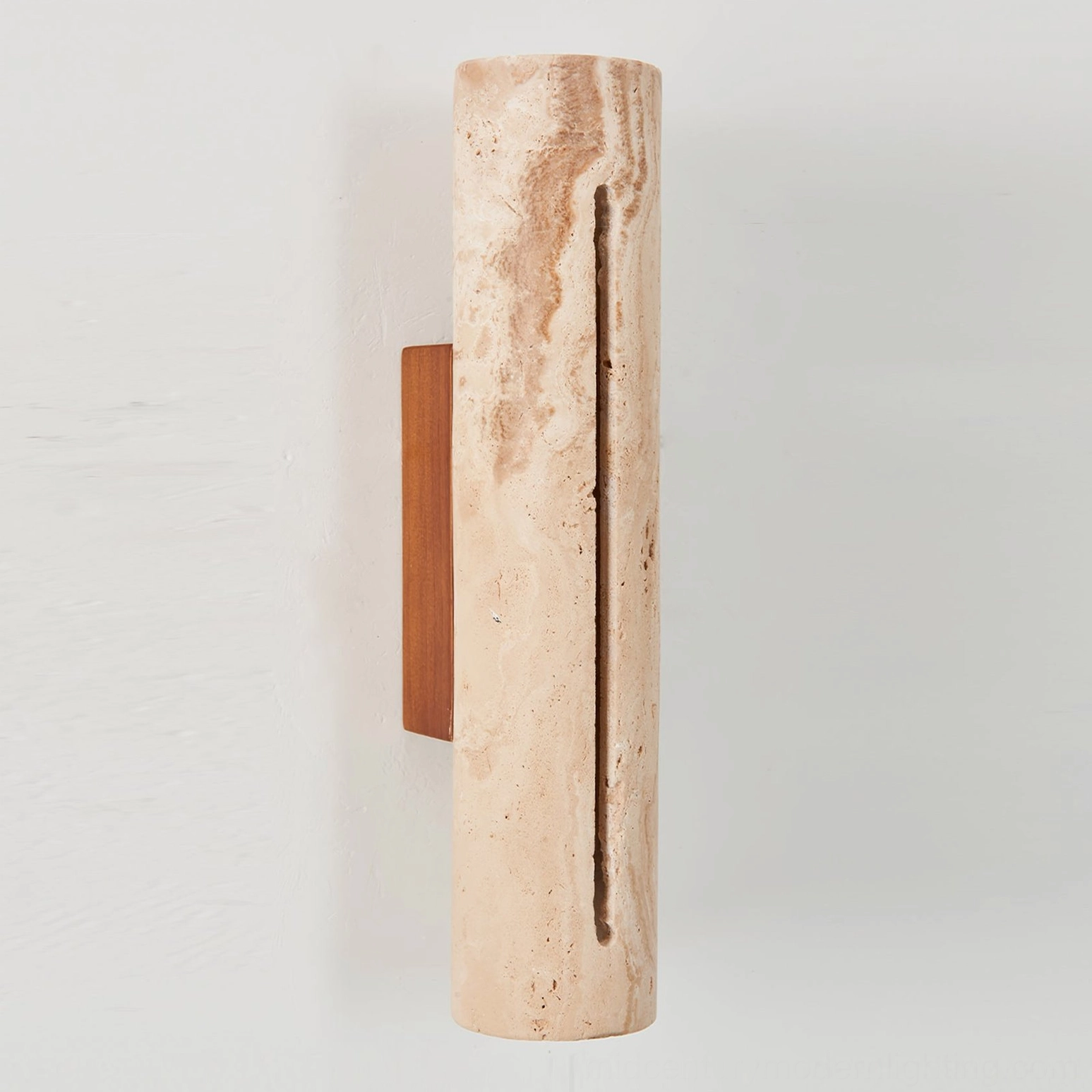 Close-up detail of Lorelei travertine sconce showing natural stone texture, veining, and honed finish with wooden backplate