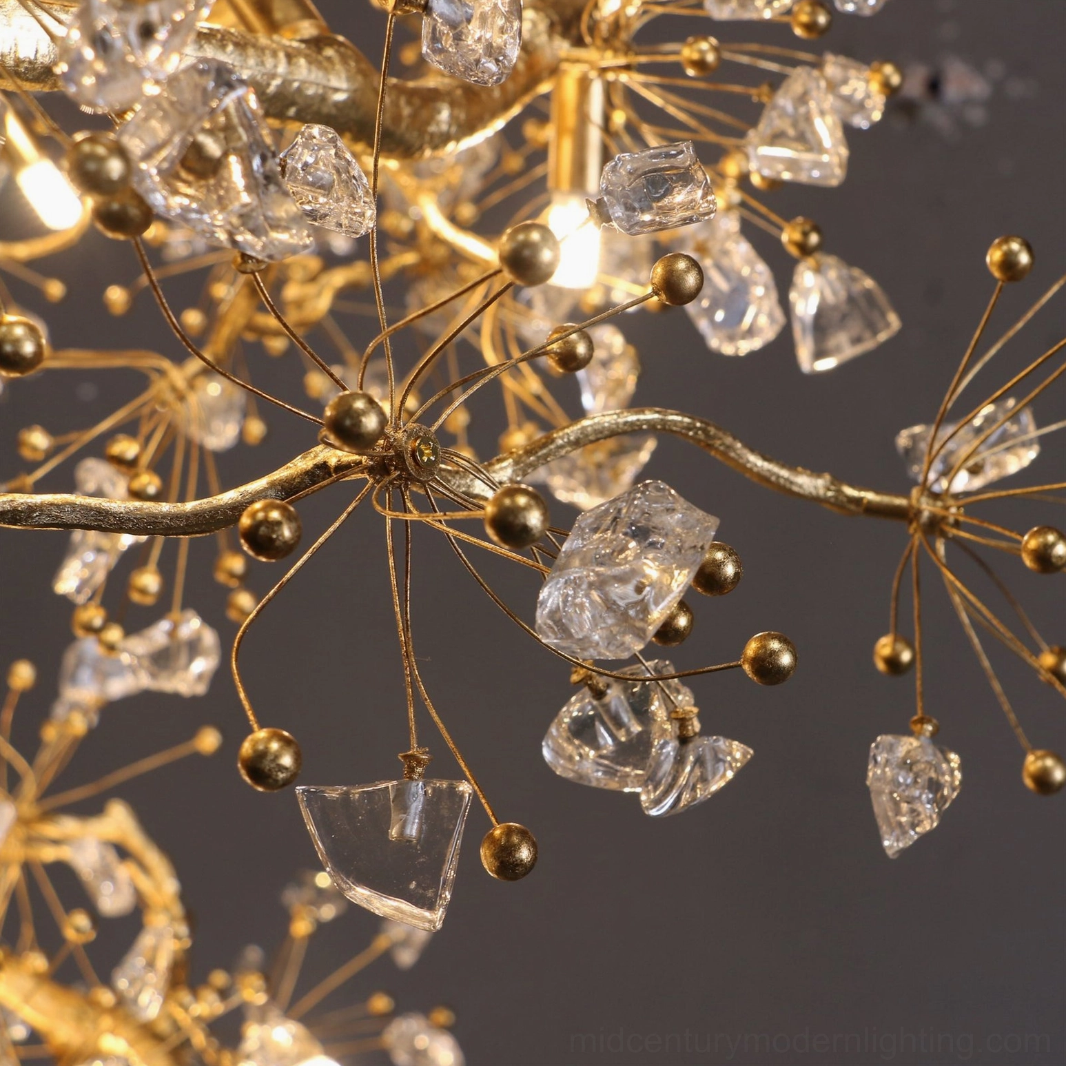 Brass berry chandelier illuminated above elegant dining setting