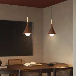 Pair of Lucian walnut and brass pendant lights above minimalist dining room table