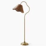 Lucinda hand-woven rattan arc floor lamp with antique brass frame and scalloped shade, studio front view